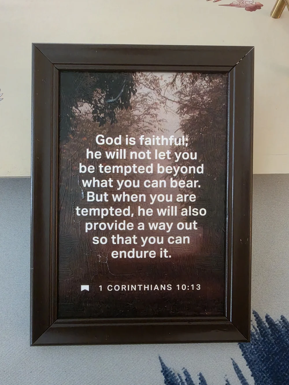 Framed print in the image features the biblical passage 1 Corinthians 10:13